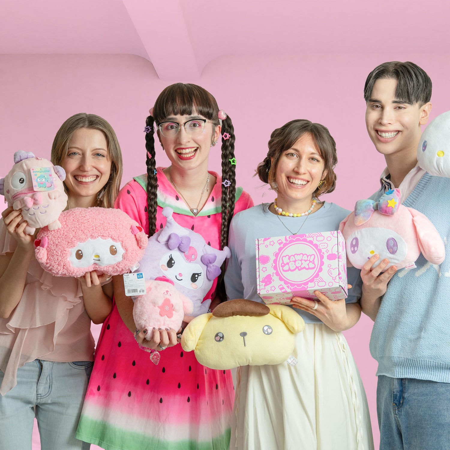 Four people holding japanese plushies and a kawaii subscription box from japan